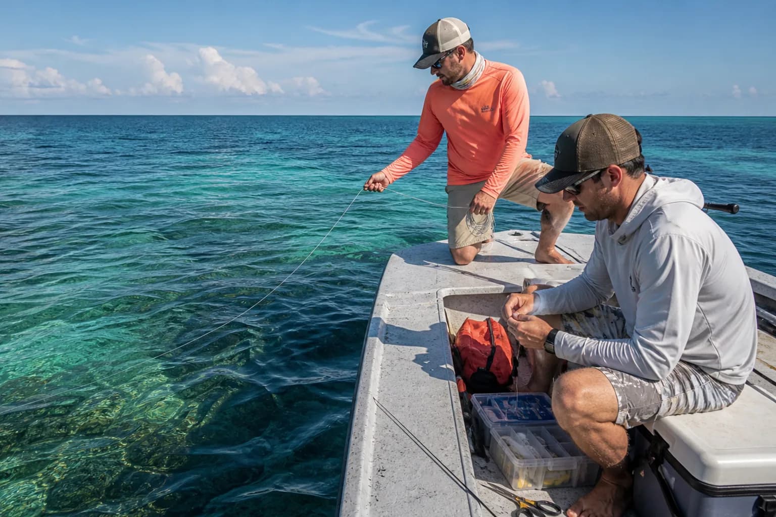 Friends using a generic underwater camera cable from a skiff above clear tropical reef water